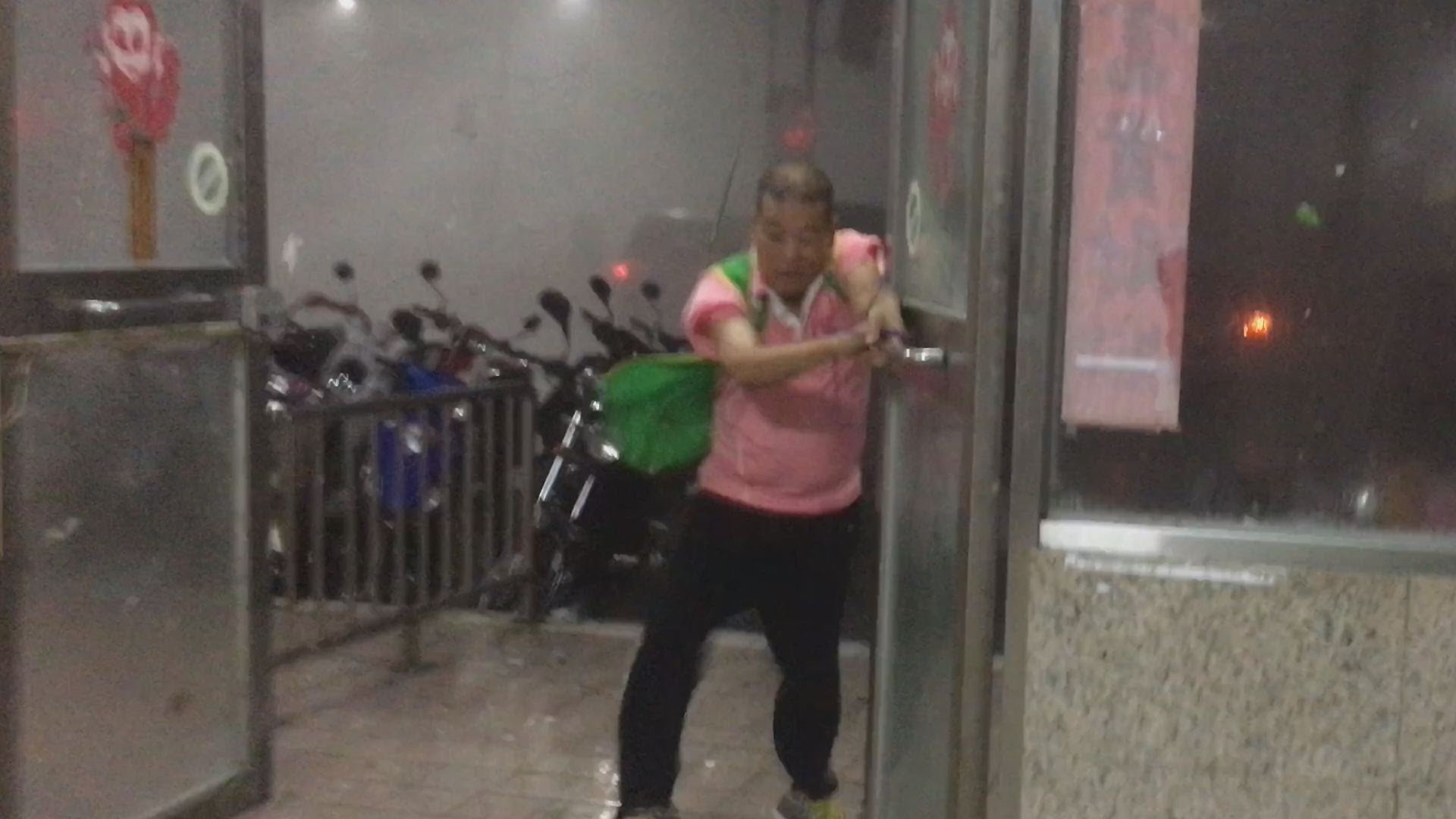 Сотрудник супермаркета попытался закрыть дверь в здание во время тайфуна