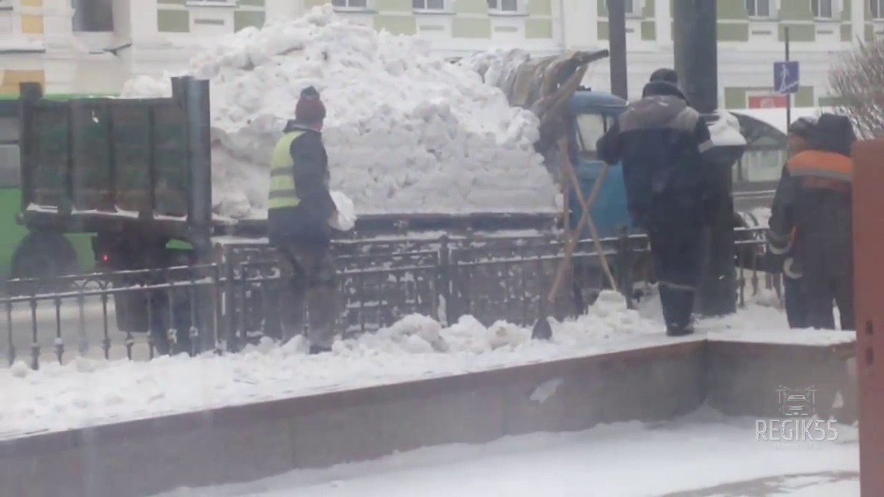 Омские коммунальщики разбрасывают снег из машины по улице