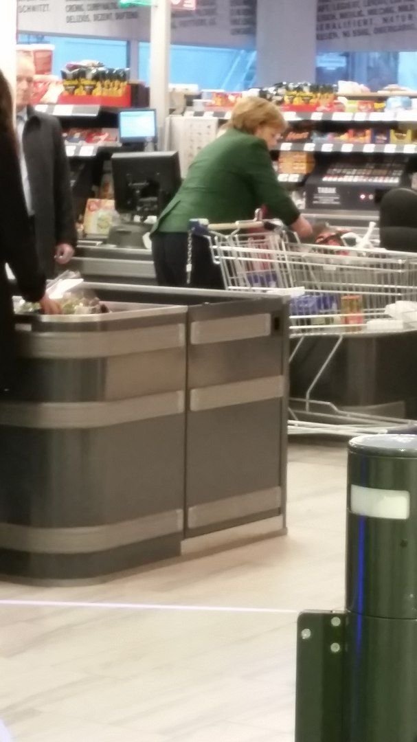 Ангела Меркель на кассе продуктового магазина с покупками