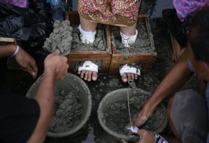Около 50 жителей Индонезии зацементировали ноги в знак протеста